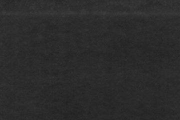 Cardboard black abstract texture close-up. Dark old paper background. Grunge concrete wall. Vintage blank wallpaper.