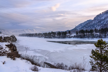 Landscape with snow-capped mountains and a freezing mountain river