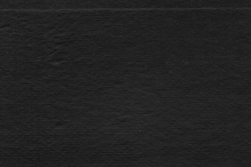 Cardboard black abstract texture close-up. Dark old paper background. Grunge concrete wall. Vintage blank wallpaper.