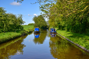 Scenic canal view with approaching narrowboat on the Llangollen Canal near Whitchurch, Shropshire, UK