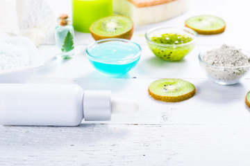 beauty products with kiwi fruit ingredient on white wooden table