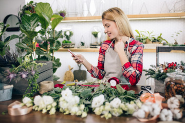 young caucasian lady with blonde hair enjoy working as florist, attractive owner of shop, young gardener around plants take care of flowers