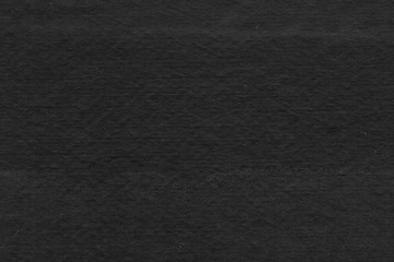 Cardboard black abstract texture close-up. Dark old paper background. Grunge concrete wall. Vintage blank wallpaper.