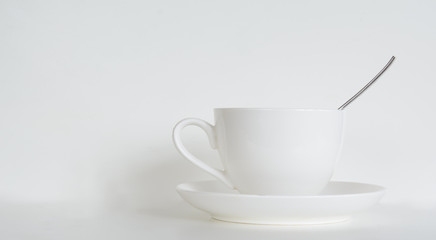 Obraz na płótnie Canvas coffee cup with saucer and a teaspoon on a white background. Concept - cafe, restaurant. Copy space