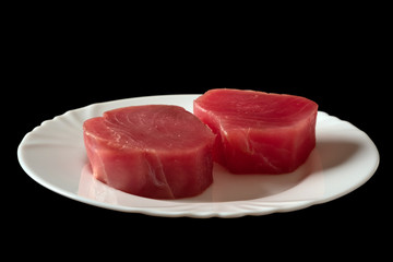 Fresh raw tuna fillet for steak on plate. Tasty fish dinner. Ingredients for cooking