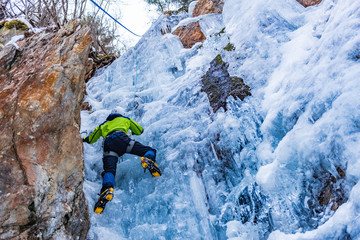 Ice Climbing Man with an Ice Axe and Crampons on a Frozen Waterfall in the Taschachschlucht (Taschach Valley) in the Pitztal in Austria