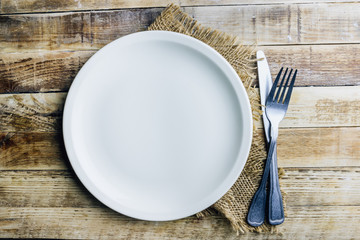 Vintage silverware on rustic wooden background. Top view of kitchen cutlery setting on grunge restaurant table.