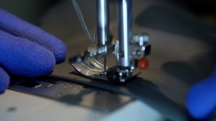 Close-up of sewing machine needle rapidly moves up and down. 