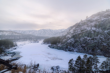 Landscape with snow-capped mountains and a freezing mountain river