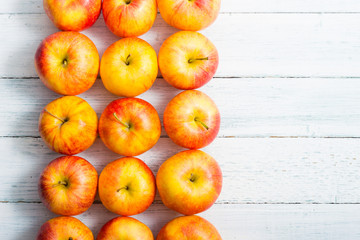 apple fruits in a row, white wooden table background