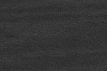 Cardboard black abstract texture close-up. Dark old paper background. Grunge concrete wall. Vintage blank wallpaper.