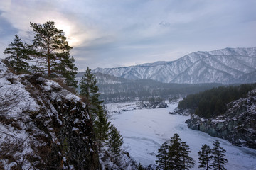 Landscape with snow-capped mountains and a freezing mountain river