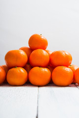 pyramid stack of mandarin oranges on shabby chic white wood table background
