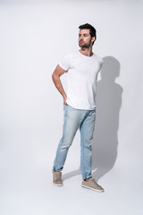 Male beauty. Full length of handsome young man in casual wear looking away while standing against grey background