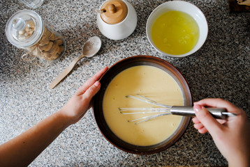 Cooking on the kitchen table, female hands mix the dough.