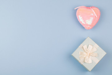 Gift or present box and pink heart on blue background. top view close up .