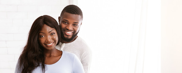 Cheerful young married couple posing over white background