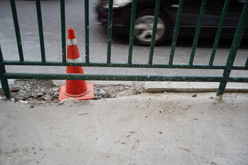 Traffic cone on damaged concrete road surface