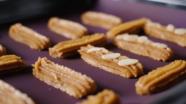 pastry chef  put almond slide on almond cookies dough for baking