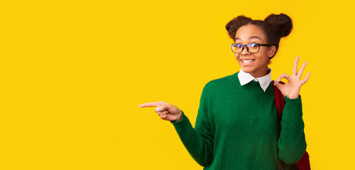 Young black woman pointing at copy space