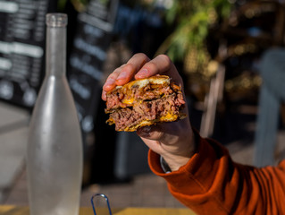 a hand taking a cheese burger 