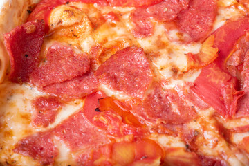 Pizza with salami  on wooden background.