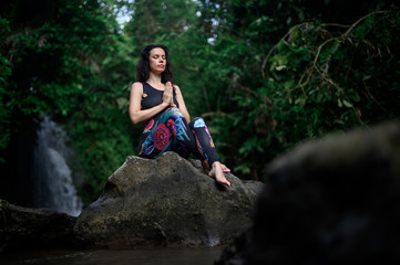 Naklejka na ściany i meble Yoga practice and meditation in nature. Woman practicing near river