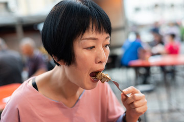 woman eat Taiwanese night market steak