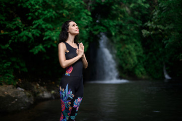 Yoga practice and meditation in nature. Woman practicing near river