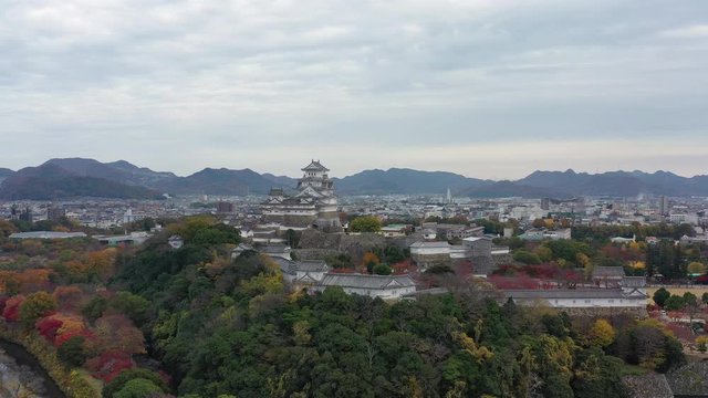 Aerial view of famous Himaji Castle, picturesque autumn scenery with medieval fortress complex and trees of many colors - landscape panorama of Japan from above, Asia