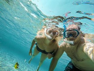 Young couple snorkeling selfie underwater camera on the coral reef in ocean of Egypt Hurghada...