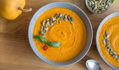 Pumpkin vegetable soup on kitchen wooden background