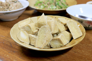 Home made of snack and dessert, Chinese Traditional Deep Fried Tofu or Fried Bean Curd Served in dish on wooden table.