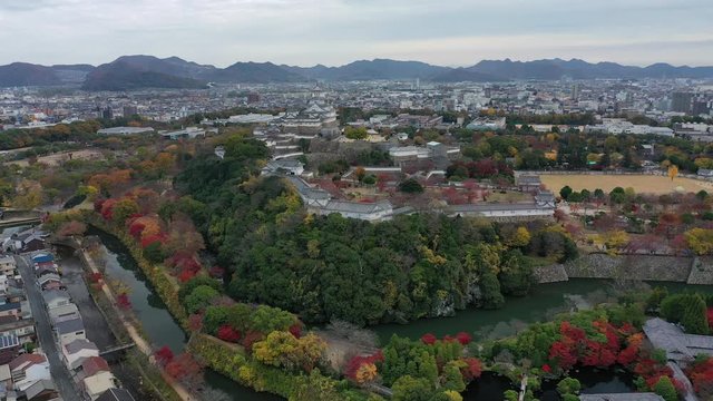 Aerial view of famous Himaji Castle, picturesque autumn scenery with medieval fortress complex and trees of many colors - landscape panorama of Japan from above, Asia