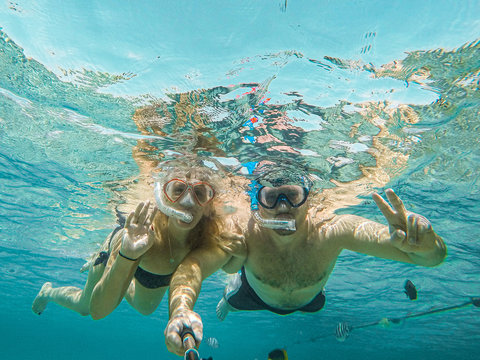 Young couple snorkeling selfie underwater camera on the coral reef in ocean of Egypt Hurghada travel concept vacation