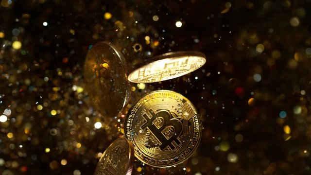 Cryptocurrencies Bitcoins flying with gold shiny glitters. 4k, 1000 fps. 4k, 1000 fps, super slow motion.