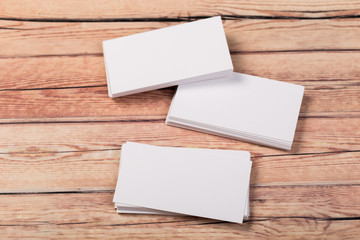 Photo of empty business cards on a light natural wooden background .. Template for identifier.