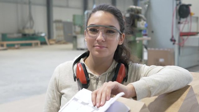 Portrait of woodwork apprentice standing in carpenter shop