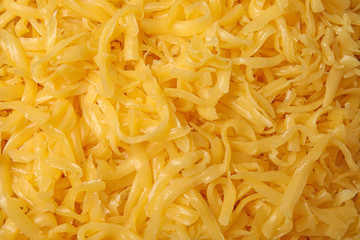 Delicious grated cheese as background, top view