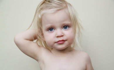 Candid portrait of adorable blonde toddler girls with blue eyes and messy hair