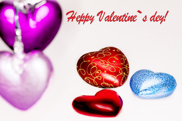 Decorative toys in the form of hearts of different colors on a white background. Valentine's day.