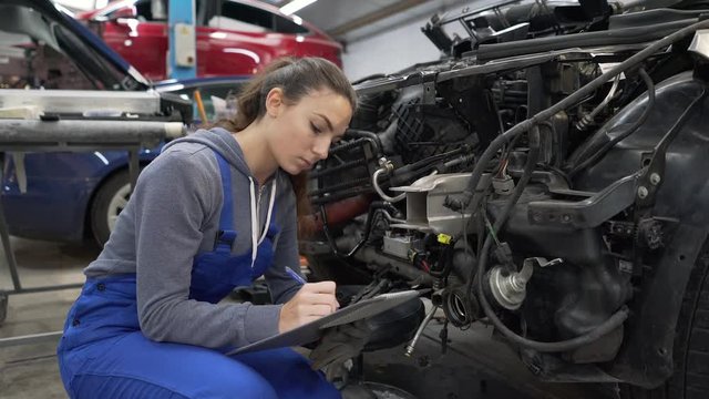 Young woman apprentice working in mechanics workshop