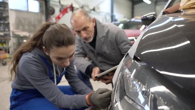 Apprentice with instructor working on vehicle