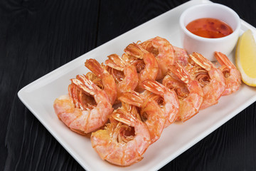 Fried shrimps with sauce and lemon on plate