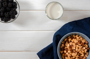 Healthy Breakfast: a healthy breakfast of cornflakes and blackberry berries on a white wooden table