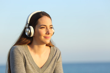 Relaxed woman wearing headphones listening to music