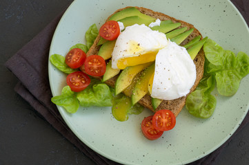 Fototapeta na wymiar poached egg on healthy bread with avocado.