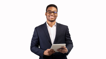 Smiling black guy standing with tablet at studio
