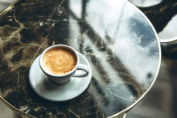 A cup of fresh fragrant morning coffee on a marble table