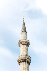 Beautiful view of the minaret of a mosque in Istanbul in Turkey against a blue sky. Religious place of worship
